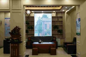 Un área de recepción con un sofá, una mesa y un pilar decorativo.