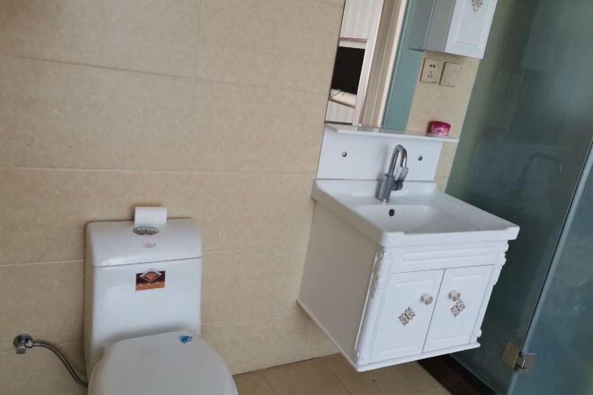 A small bathroom with a toilet, sink, and cabinet.