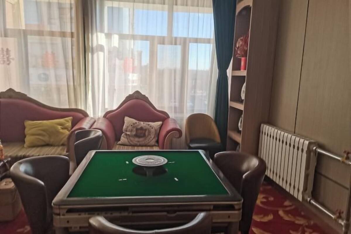 A room with a pool table, a sofa, and a radiator.