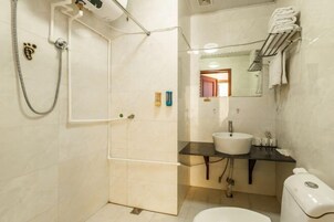 Un baño con ducha, inodoro, lavabo y toallero.