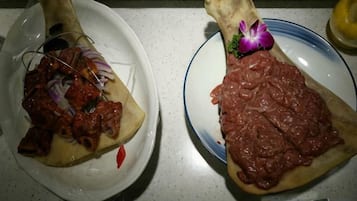 Two plates with food items on a countertop.