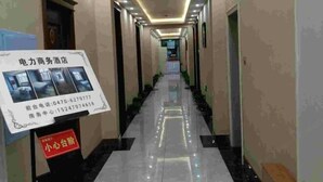Un couloir d’hôtel avec un panneau indiquant les services proposés et les numéros de téléphone à contacter.