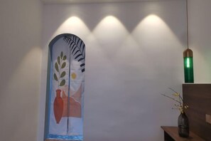 A room with a white wall, a door with a leaf and vase design, and a green pendant light. - Ruisiyuan Inn (Huzhou)