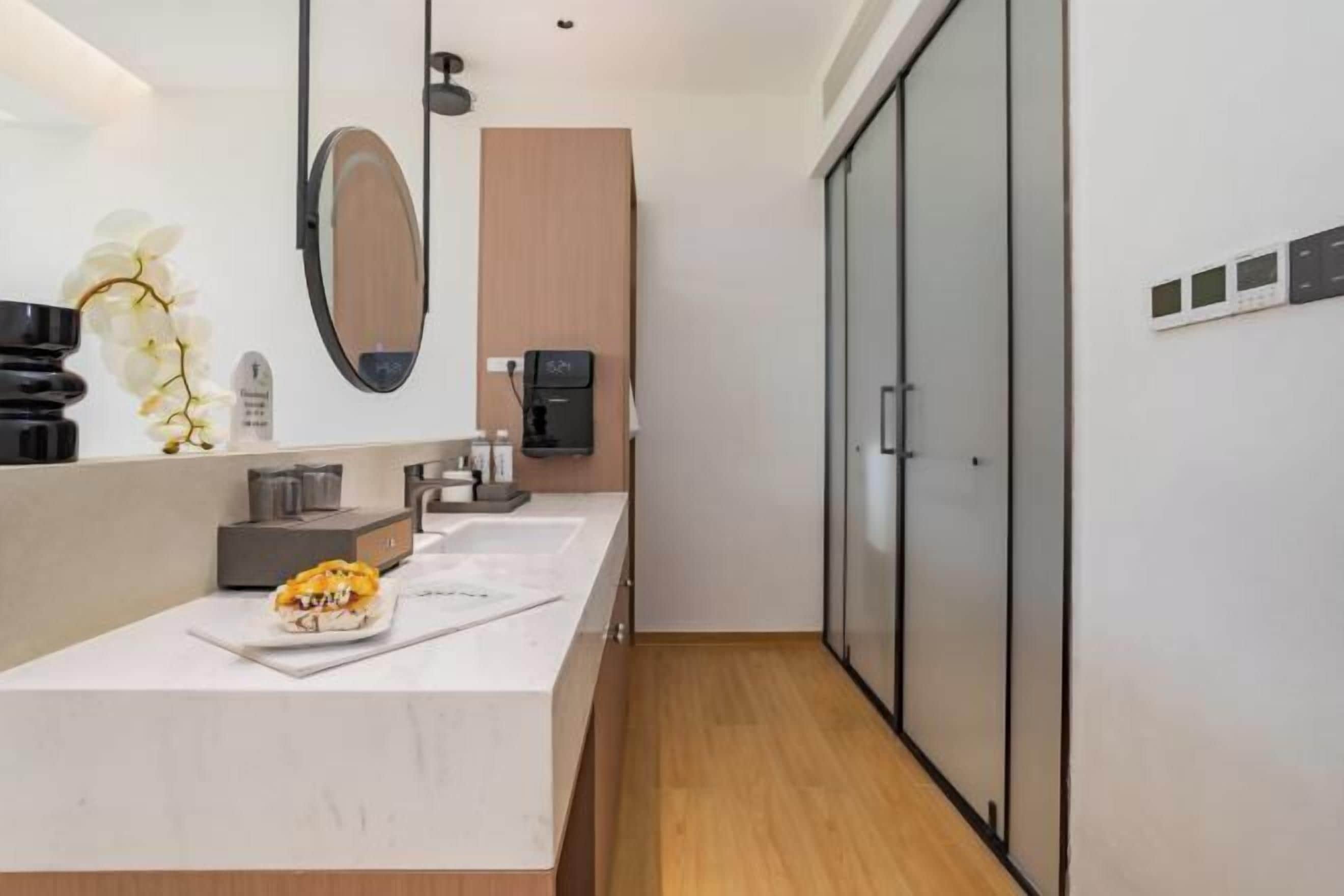 Une salle de bain moderne avec un grand miroir, un lavabo et des toilettes.