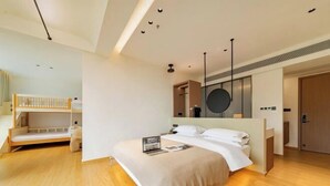 A modern bedroom with a bunk bed, a large bed, a mirror, and a wooden floor. - Anji Shanya Minsu Guesthouse (Anji)