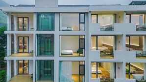 A modern multi-story hotel with large windows, balconies, and a central staircase. - Anji Shanya Minsu Guesthouse (Anji)