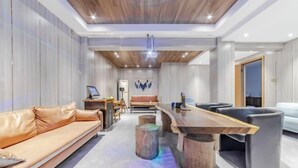 A modern living room with a wooden ceiling, a sofa, a coffee table, and a TV. - Anji Shanya Minsu Guesthouse (Anji)