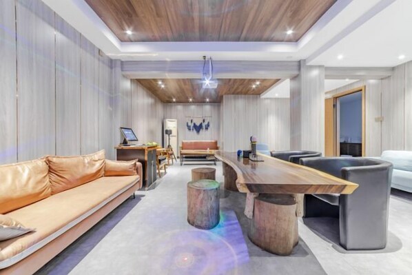 A modern living room with a wooden ceiling, a sofa, a coffee table, and a TV.