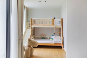 Habitación con literas, un oso de peluche y un juguete en la litera inferior.