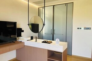 A modern bathroom with a large mirror, a television, and a vanity with a marble countertop. - Anji Shanya Minsu Guesthouse (Anji)