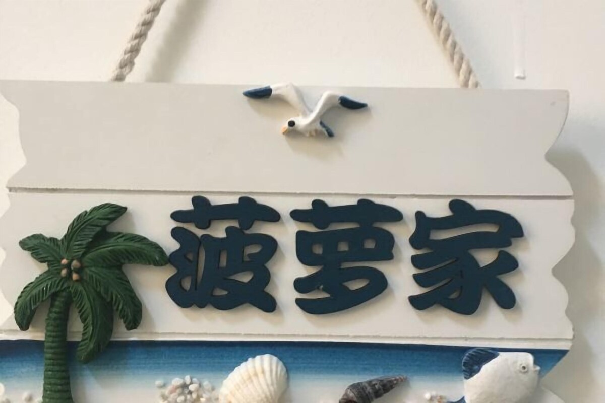 Un cartello decorativo con caratteri cinesi e una palma, probabilmente che indica un locale a tema.