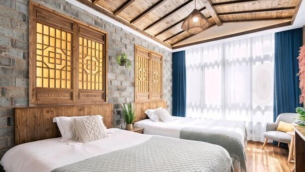Una habitación con dos camas, un escritorio y una ventana con cortinas.