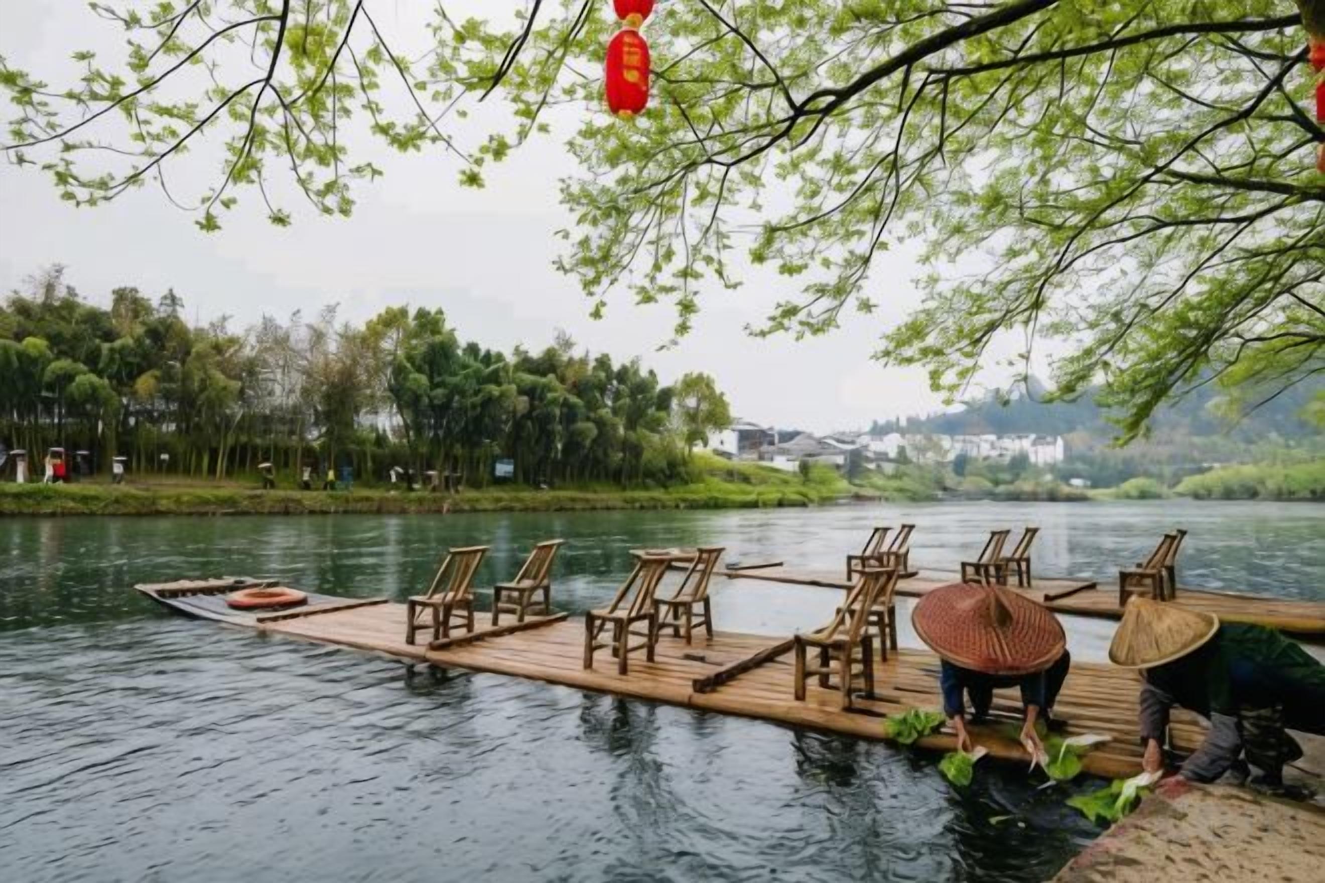 Una barca de madera con sillas y un sombrero cónico en un río tranquilo.