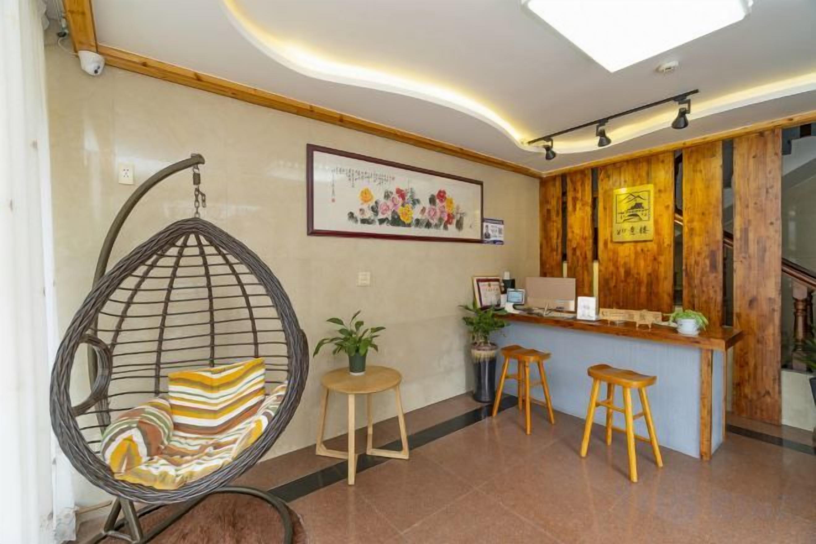 A reception area with a hanging chair, a reception desk, and a staircase.