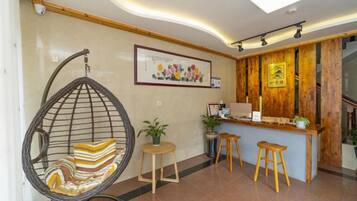 A reception area with a hanging chair, a reception desk, and a staircase.