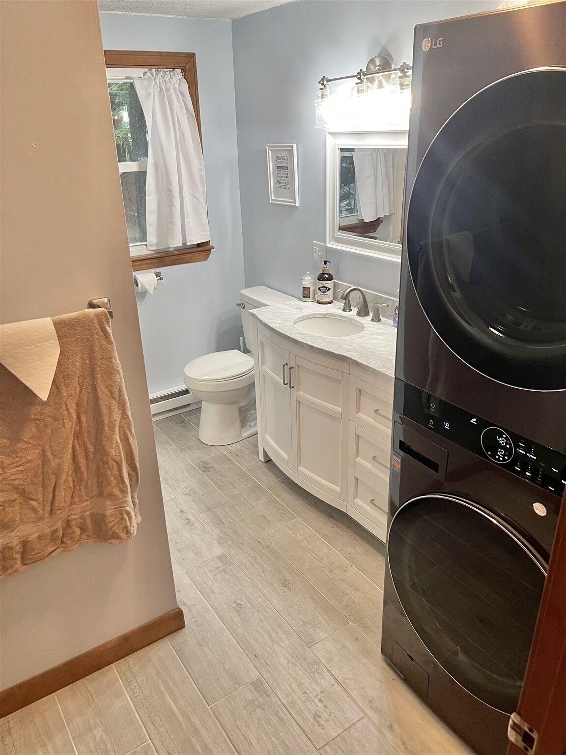 A bathroom with a toilet, sink, and a washing machine.