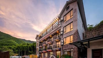Un hotel de varios pisos con un diseño arquitectónico moderno, que cuenta con balcones y ventanas amplias.