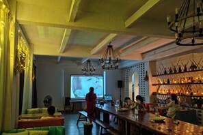 A bar area with a projection screen, seating, and a bar counter. - Xianbu Tingxia Villa (Deqing)