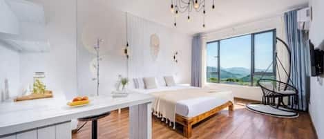 Une chambre moderne avec un grand lit, un bureau et une vue sur l’extérieur.