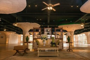 A spacious interior with a ceiling fan, bookshelves, a sofa, and a coffee table. - Luminggu Hotel (Luzhai)
