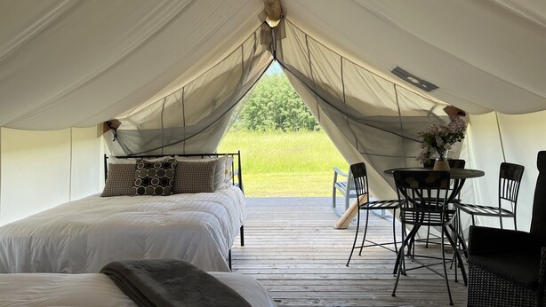 A tented accommodation with two beds, a dining table, and chairs. - Heritage Ranch 'Big Sky' Glamping Tent (11) (Bozeman)