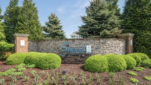 A stone wall with the name "Grande" and a sign indicating a canal fountain. - Grande Getaway Walking Distance to the Beach (Rehoboth Beach)