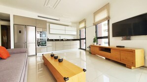 Een moderne keuken met witte kastjes, een inbouwoven en een groot raam.