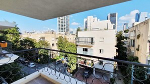 A balcony with a metal railing, overlooking a cityscape with various buildings, including a tall skyscraper. - Yosef Terracotta in Tel Aviv-yafo (Tel Aviv)