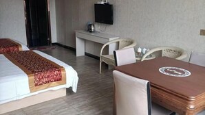 A hotel room with two beds, a desk with a television, a table with a logo, and wicker chairs. - Jinhaiwan Homestay (Jixian Passenger Station) (Ji County)