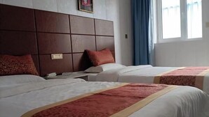 A hotel room with two beds, a wooden headboard, a nightstand, and a window with curtains. - Jinhaiwan Homestay (Jixian Passenger Station) (Ji County)