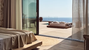 Un dormitorio con un amplio ventanal corredera que da a un balcón con vistas al mar.
