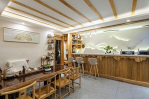 Ein Essbereich aus Holz mit einer Theke, Stühlen und einem Wandventilator.