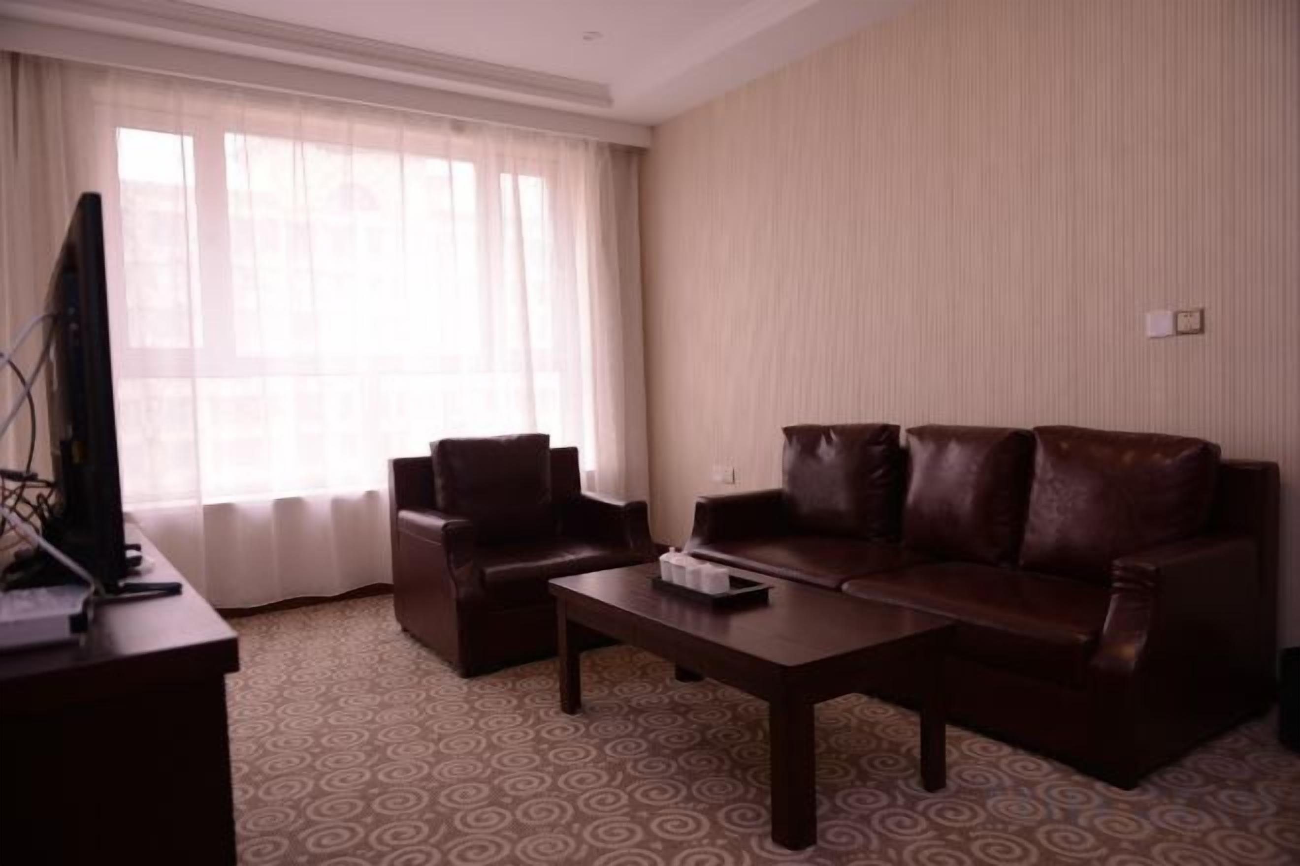 Una sala de estar con un sofá, una mesa de centro y un televisor sobre un mueble.