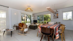 Una sala de estar moderna con comedor, ventanas amplias y una chimenea acogedora.