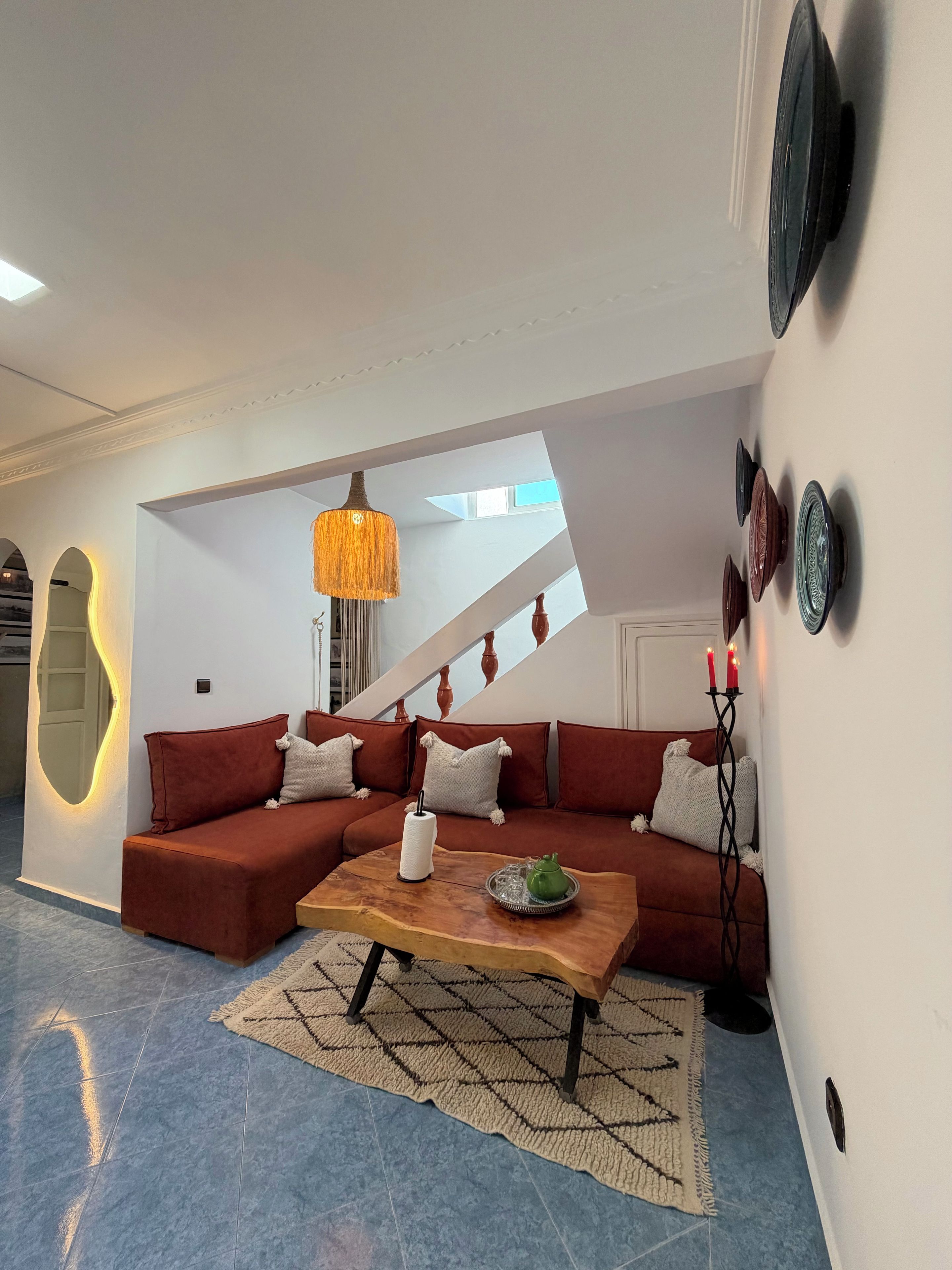A modern living room with a sectional sofa, a coffee table, and a staircase leading to an upper level.