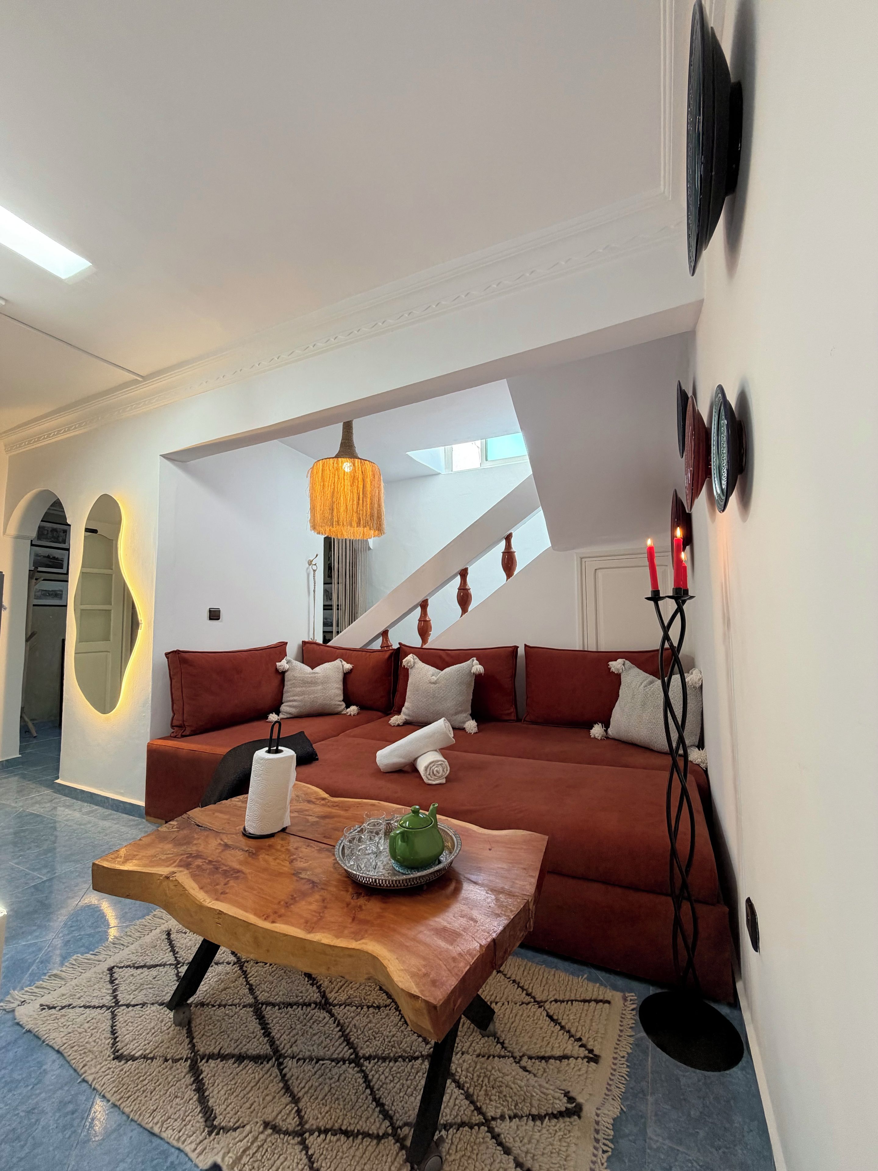 Een moderne woonkamer met een bank, een houten salontafel en een hanglamp.