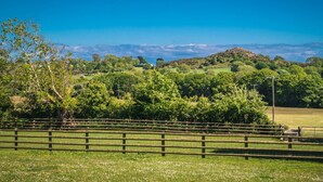 A rural landscape with a wooden fence, lush greenery, and a hill in the background. - CRAFNANT -  a cottage that sleeps 4 guests  in 2 bedrooms (Pwllheli)