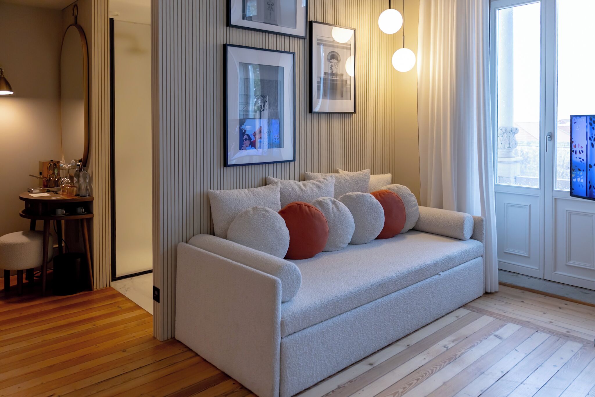 A modern living room with a sofa, a small table, and framed pictures on the wall.