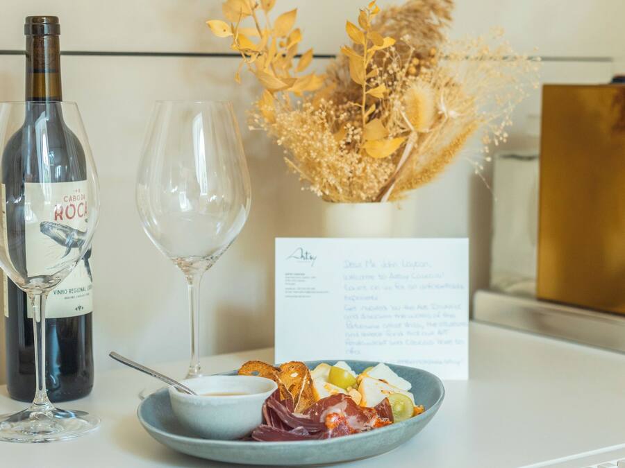 A table with a bottle of wine, an empty wine glass, a plate with food, and a menu.