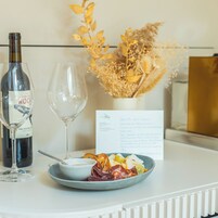 Ein Tisch mit einer Weinflasche, einem leeren Weinglas, einem Teller mit Essen und einer Speisekarte.