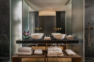 Un baño moderno con dos lavamanos tipo recipiente, un espejo y una ducha.