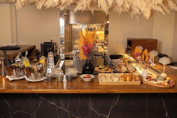 A buffet setup with various food items, a coffee station, and a decorative centerpiece. - ARTSY Cascais (Cascais)
