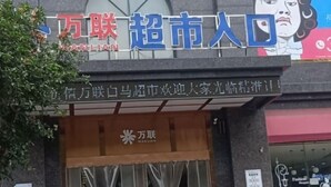 A storefront with a sign that reads "万联超市" and "万联超市入口" indicating the entrance to a supermarket. - Yinhe Hotel (Qiyang)