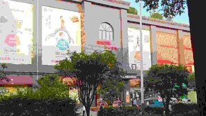 A building facade with large advertisements, a central arched window, and surrounding greenery. - Yinhe Hotel (Qiyang)