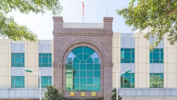 A building with a central arched entrance, large windows, and a flag on top. - Yin Xi Hotel (Huidong)