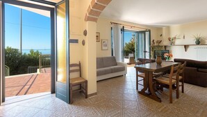 A spacious living area with a large sliding glass door leading to a terrace, a dining table with chairs, a sofa, and a coffee table. - 3169 Villa Enea by Barbarhouse (Porto Cesareo)