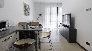 Cozy living space with a dining area, kitchenette, and seating area featuring a TV.