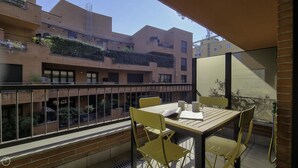 A balcony with a table and chairs, overlooking a courtyard with buildings. - Italianway Easy - Zuretti 32 (Milan)