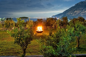A well-maintained garden with a central fire feature, surrounded by neatly trimmed bushes and trees. - Villa Artemisia in Piano di Sorrento (Piano di Sorrento)