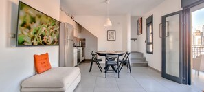 A modern apartment with a kitchen, dining area, and a balcony.